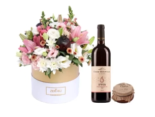 a  flower arrangement. honey jar and red wine