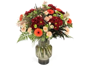 'Carmen' flower bouquet in shades of red, orange and yellow combined with decorative branches